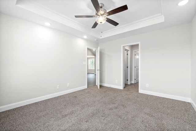 unfurnished bedroom with crown molding, ceiling fan, carpet flooring, and a raised ceiling