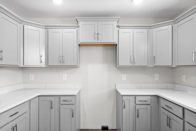 kitchen with light stone counters and gray cabinets