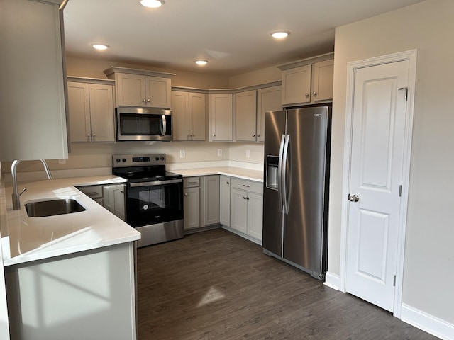 kitchen featuring stainless steel appliances, sink, dark hardwood / wood-style flooring, and gray cabinets