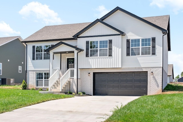 raised ranch featuring a garage, central AC, and a front yard