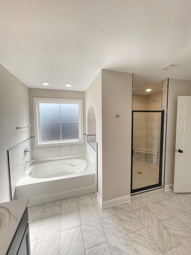 bathroom with vanity and shower with separate bathtub