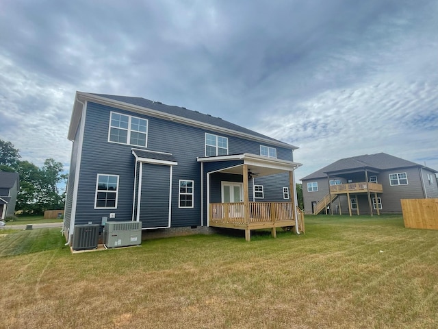 back of property featuring central AC unit, a lawn, and a deck