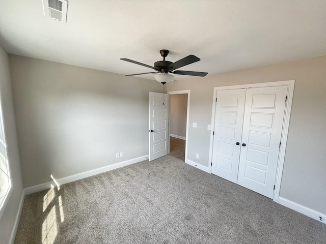 unfurnished bedroom with a closet, ceiling fan, and carpet flooring