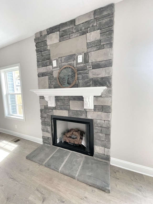 details featuring hardwood / wood-style floors and a stone fireplace