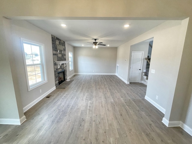 unfurnished living room with ceiling fan, a fireplace, and hardwood / wood-style floors