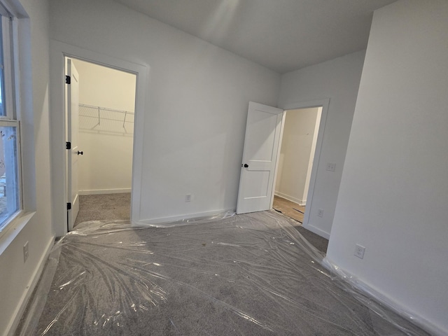 unfurnished bedroom featuring a walk in closet and a closet