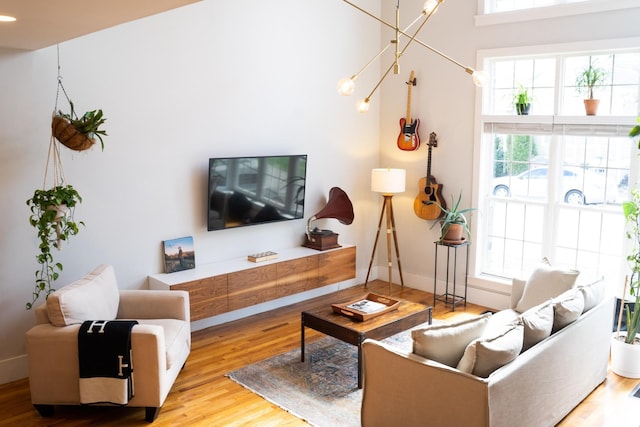 living room with a towering ceiling and light hardwood / wood-style flooring