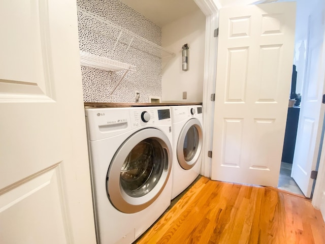 washroom with wood-type flooring and washing machine and clothes dryer