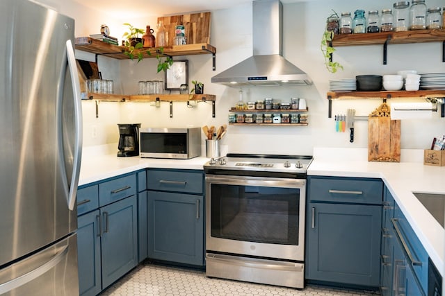 kitchen featuring appliances with stainless steel finishes, blue cabinets, and exhaust hood