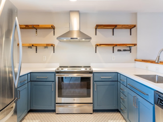 kitchen featuring blue cabinetry, open shelves, wall chimney range hood, stainless steel appliances, and a sink