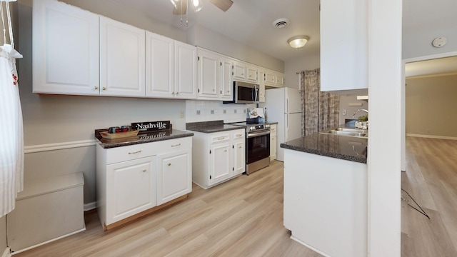 kitchen featuring sink, white cabinetry, stainless steel appliances, tasteful backsplash, and light hardwood / wood-style floors