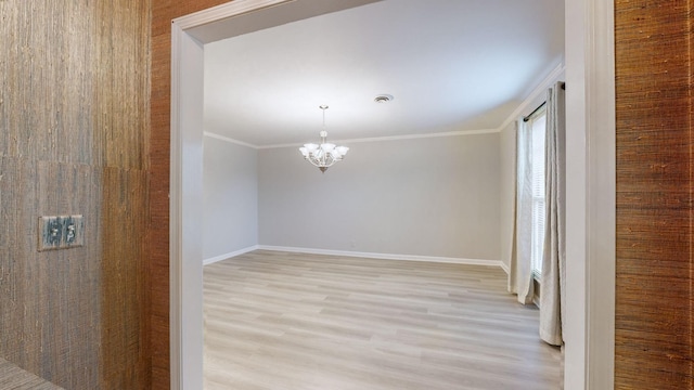 unfurnished room with crown molding, a chandelier, and light hardwood / wood-style flooring