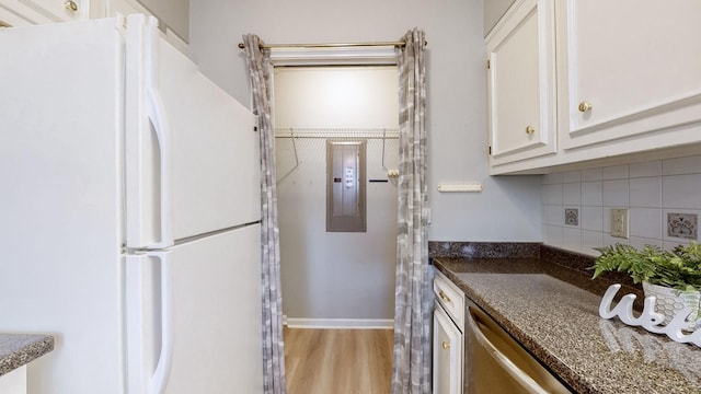 kitchen featuring white cabinetry, backsplash, stainless steel dishwasher, dark stone counters, and white fridge