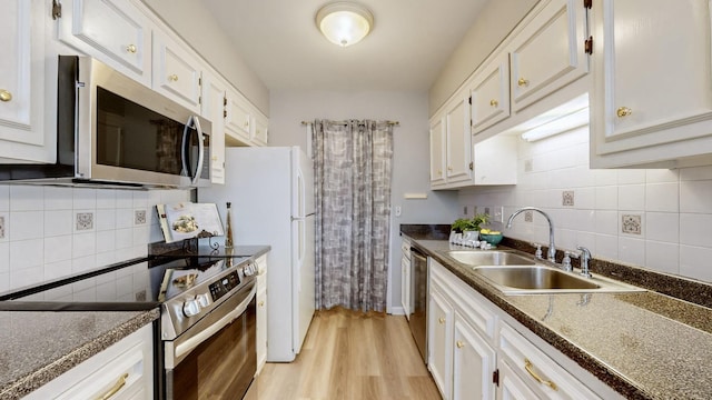 kitchen with sink, appliances with stainless steel finishes, backsplash, light hardwood / wood-style floors, and white cabinets