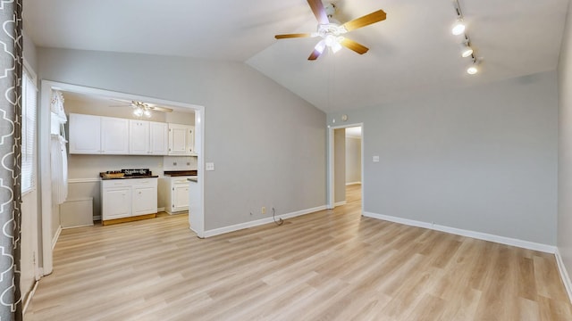 unfurnished living room with ceiling fan, lofted ceiling, track lighting, and light hardwood / wood-style floors