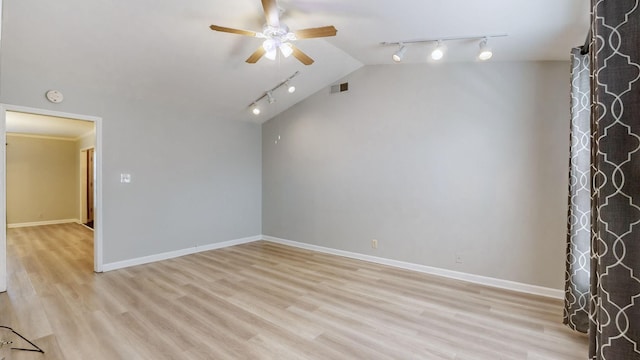 interior space with lofted ceiling, light hardwood / wood-style flooring, rail lighting, and ceiling fan