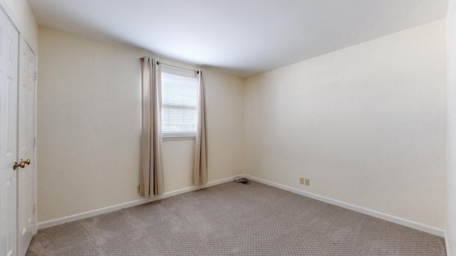 spare room featuring light colored carpet