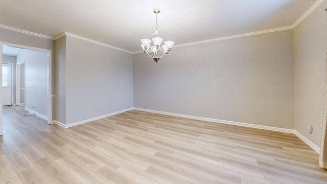 spare room with ornamental molding, an inviting chandelier, and light hardwood / wood-style flooring