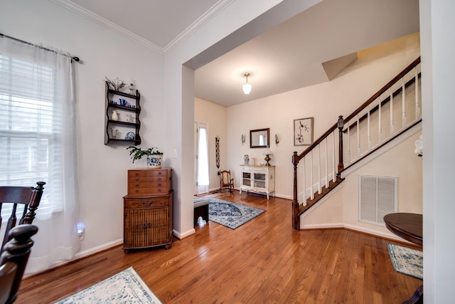 entryway with crown molding and wood-type flooring