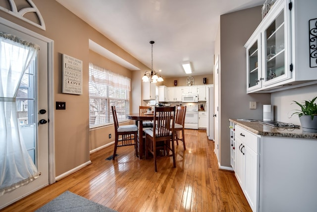 dining space with an inviting chandelier and light wood-type flooring