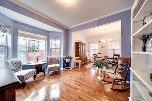 sitting room with a notable chandelier, hardwood / wood-style flooring, and ornamental molding