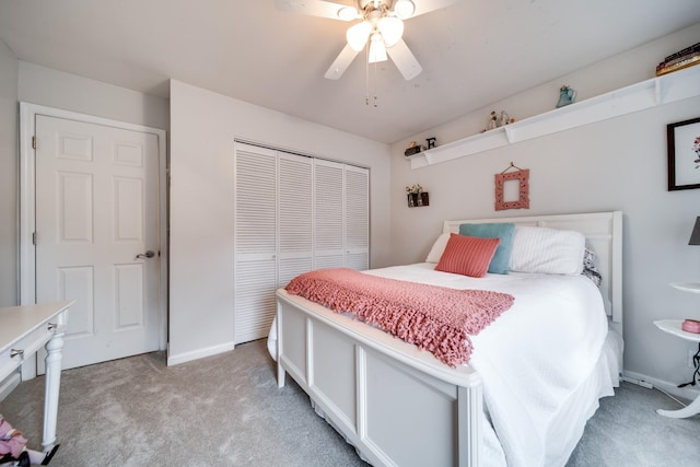 bedroom featuring light colored carpet, ceiling fan, and a closet