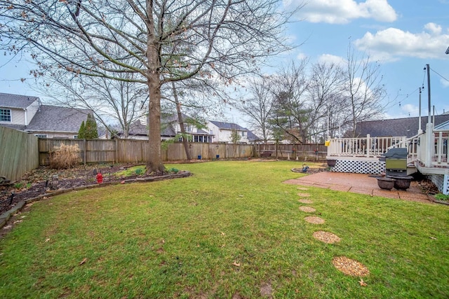 view of yard featuring a wooden deck and a patio