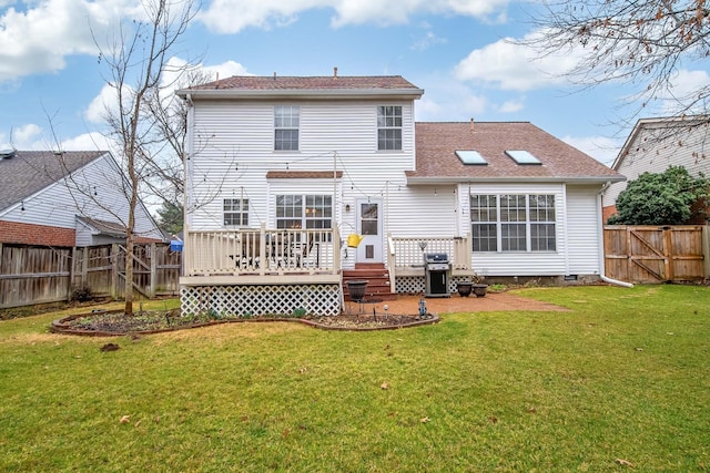 rear view of property featuring a deck and a lawn