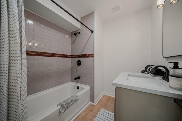 bathroom featuring vanity, hardwood / wood-style floors, and shower / tub combo