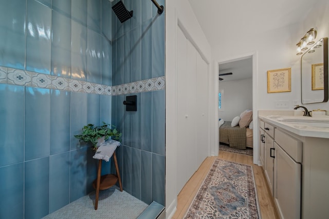 bathroom featuring hardwood / wood-style flooring, vanity, and walk in shower