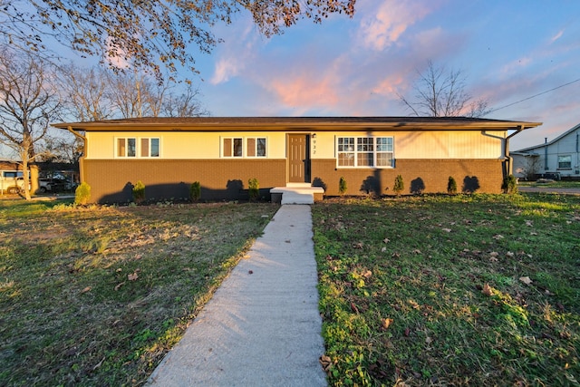 ranch-style home featuring a yard