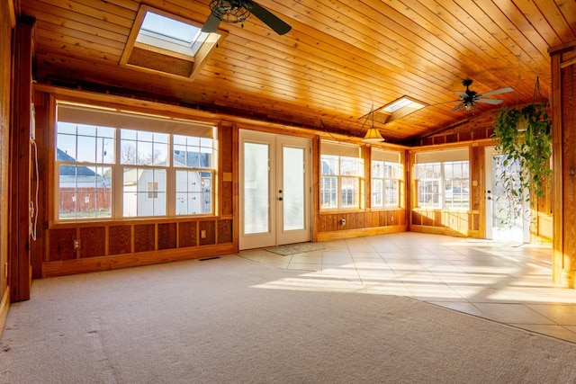 unfurnished sunroom featuring lofted ceiling with skylight, wooden ceiling, and ceiling fan