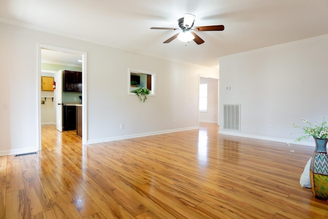 unfurnished living room with crown molding, ceiling fan, and light hardwood / wood-style flooring