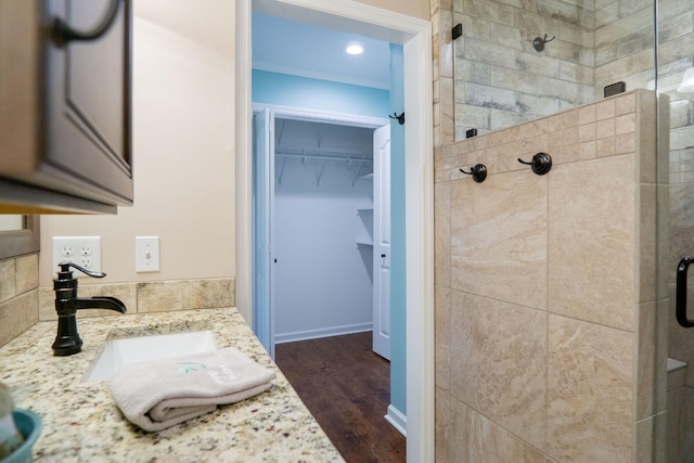 bathroom featuring hardwood / wood-style flooring, vanity, and an enclosed shower