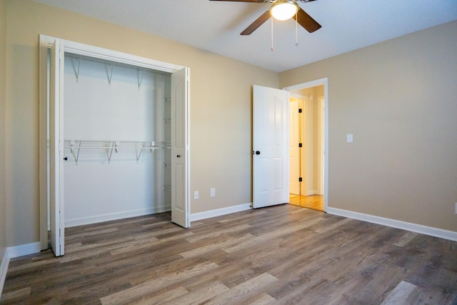 unfurnished bedroom featuring wood-type flooring, ceiling fan, and a closet