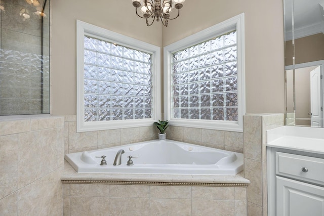 bathroom featuring an inviting chandelier, vanity, and a relaxing tiled tub