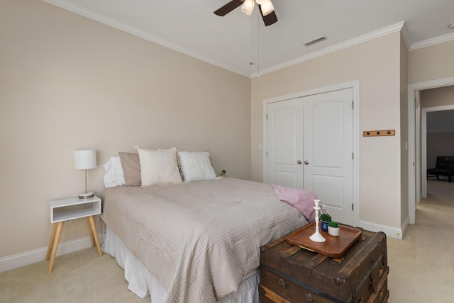 bedroom featuring ceiling fan, a closet, ornamental molding, and light carpet