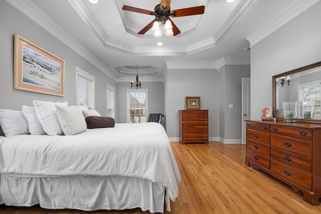 bedroom with crown molding, a tray ceiling, ceiling fan with notable chandelier, and light hardwood / wood-style floors