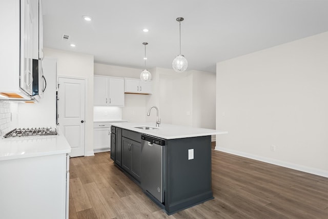 kitchen featuring pendant lighting, sink, appliances with stainless steel finishes, a kitchen island with sink, and white cabinetry