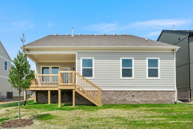 rear view of house featuring cooling unit, a yard, and a deck