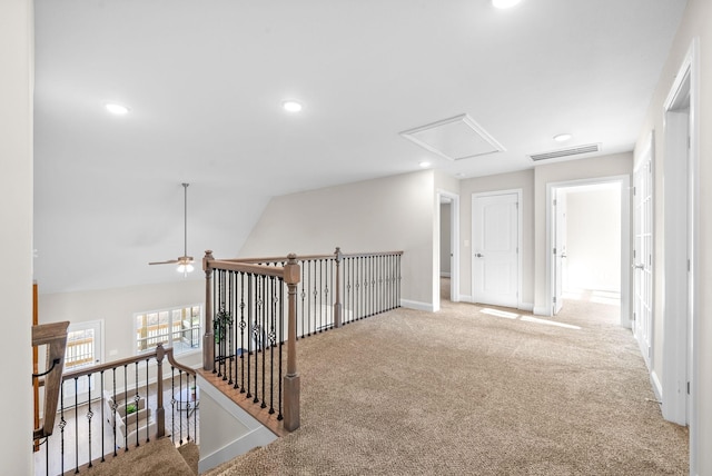 hall with vaulted ceiling and light colored carpet