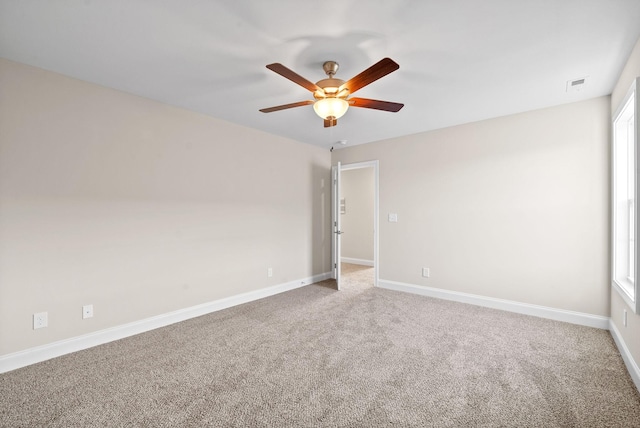 carpeted spare room with a wealth of natural light and ceiling fan