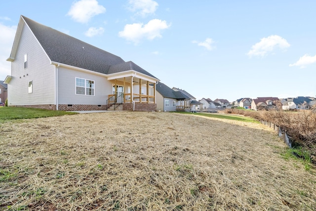 back of property featuring a porch and a lawn