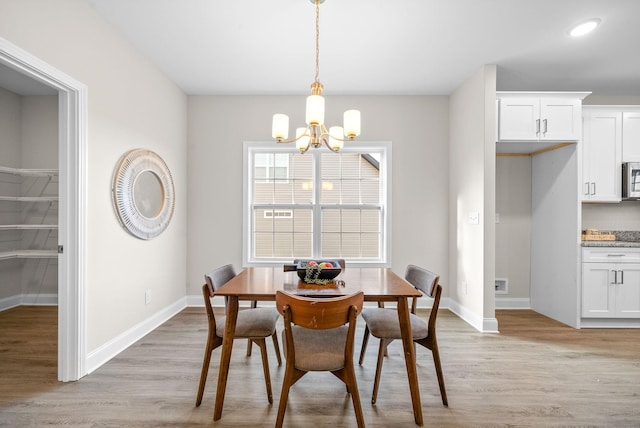 dining area featuring an inviting chandelier and light wood-type flooring