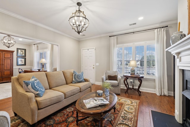 living room with an inviting chandelier, dark hardwood / wood-style floors, and crown molding