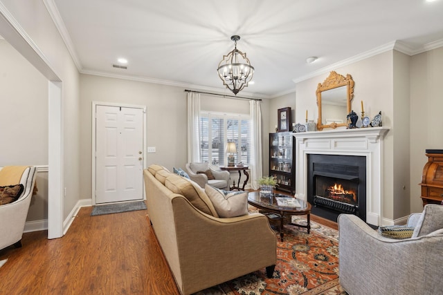 living room with a notable chandelier, hardwood / wood-style flooring, and ornamental molding