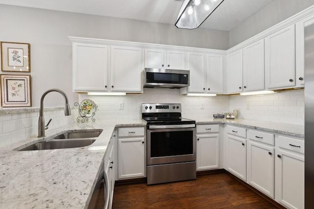 kitchen with light stone countertops, appliances with stainless steel finishes, sink, and white cabinets