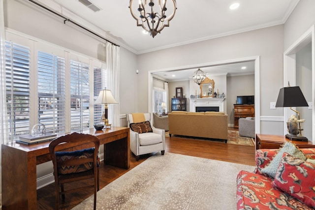 sitting room with a notable chandelier, hardwood / wood-style flooring, and ornamental molding