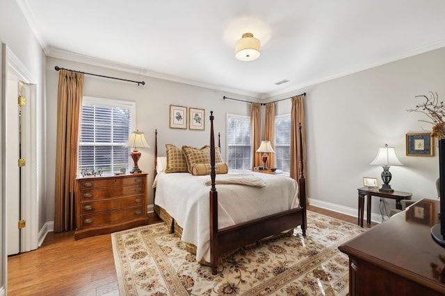 bedroom featuring multiple windows, crown molding, and light hardwood / wood-style floors