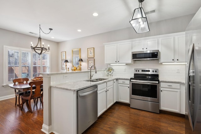 kitchen featuring white cabinetry, stainless steel appliances, sink, and hanging light fixtures